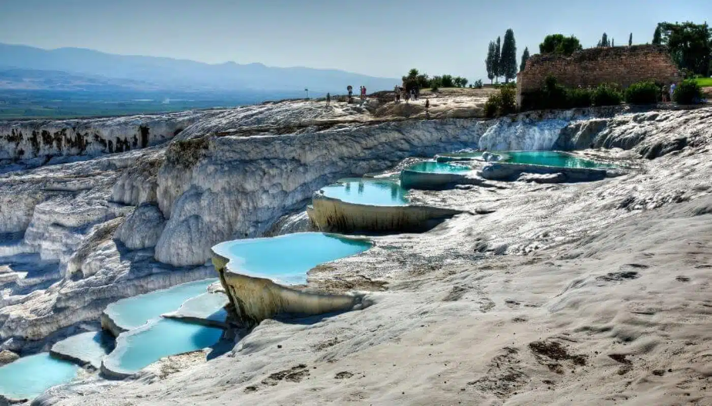 White travertine terraces of Pamukkale, Turkey, shimmering under clear skies.