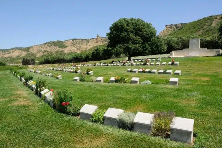 Ariburnu Cemetery in Gallipoli, rows of white headstones against serene landscape.