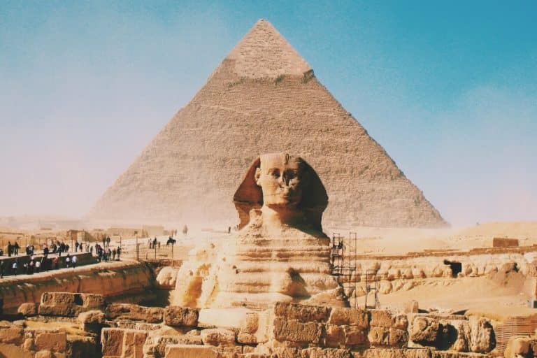 Explore the Pyramids of Giza tour in Cairo, showcasing ancient limestone structures under a clear sky.