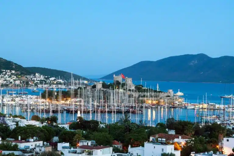 Aerial view of Bodrum City, Turkey, showcasing whitewashed buildings, the vibrant blue Aegean Sea, and the historic Bodrum Castle.