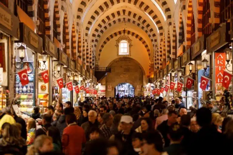 Colorful entrance of the Grand Bazaar in Istanbul, bustling with people and lined with shops and lanterns.